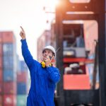 Container yard worker checking container at container yard warehouse,Logistics transportation and shipping business concepts.